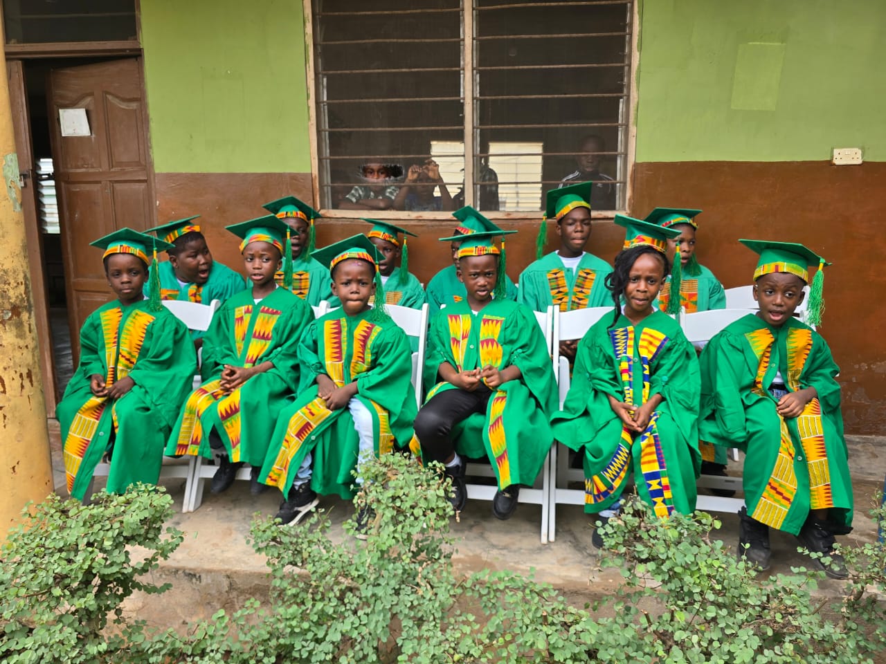 Graduating pupils in gowns and kente stoles waiting for the ceremony to begin