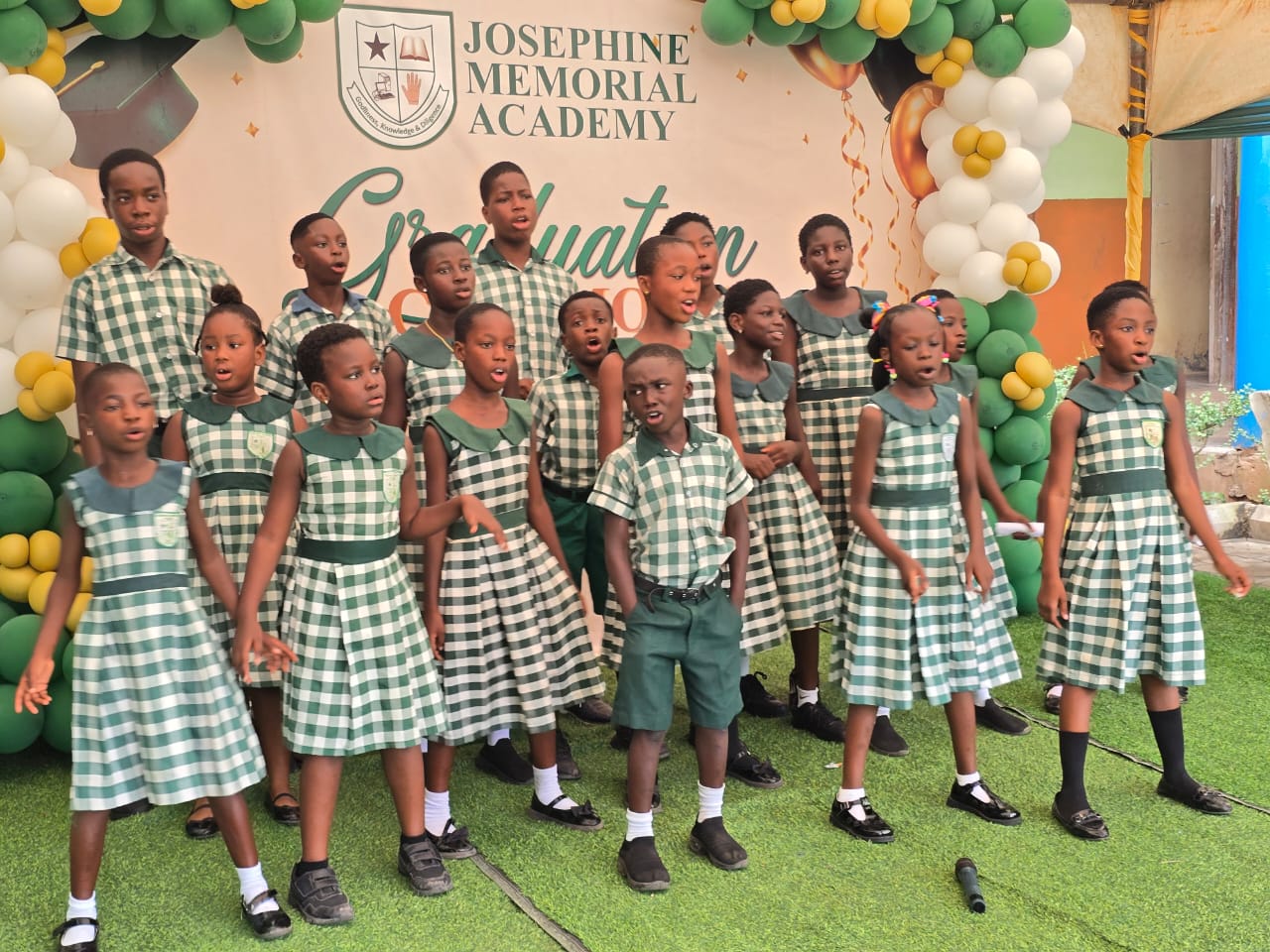 Pupils in school uniform singing at the graduation ceremony